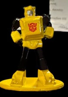 Small yellow toy robot with red emblem